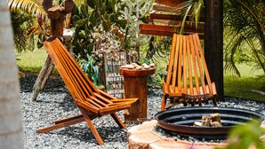 A wooden bench with a sign that reads 'CARNIVAL RULES' in a garden setting.