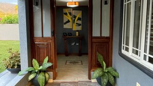 A hallway with a tiled floor, wooden doors, and two potted plants. - Private Kingston 6 Villa w/ Pool, Swim-Up Bar & Outdoor Kitchen Near Liguanea (Kingston)