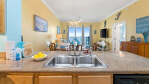 Una cocina con encimeras de granito, pileta doble y comedor con vista.
