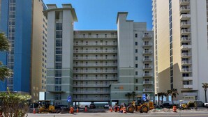 Un hotel de varios pisos con un atrio central, balcones en cada planta y un cielo despejado.