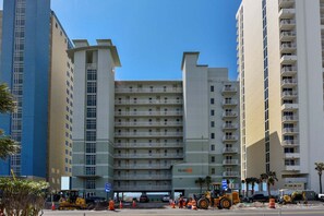 A multi-story hotel with a central atrium, balconies on each floor, and a clear sky. - Beachfront Bliss: 3-bedroom, 2-bath condo in Panama City Beach, sleeps 7. (Panama City Beach)