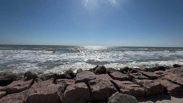 A rocky shoreline with waves, clear sky, and sunlight. - Perfect  1-bedroom RV getaway located in Surfside Beach.  (Surfside Beach)