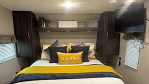 A bedroom with a bed, a television, and a sign on the wall. - Perfect  1-bedroom RV getaway located in Surfside Beach.  (Surfside Beach)