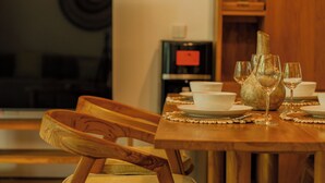 A dining table with plates, glasses, and a vase. - Premier Umalas Seminyak (Keroboken Kelod)