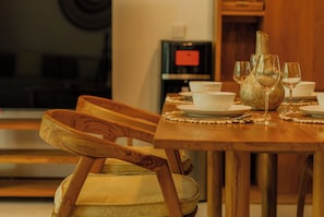 Ein Esstisch mit Tellern, Gläsern und einer Vase.