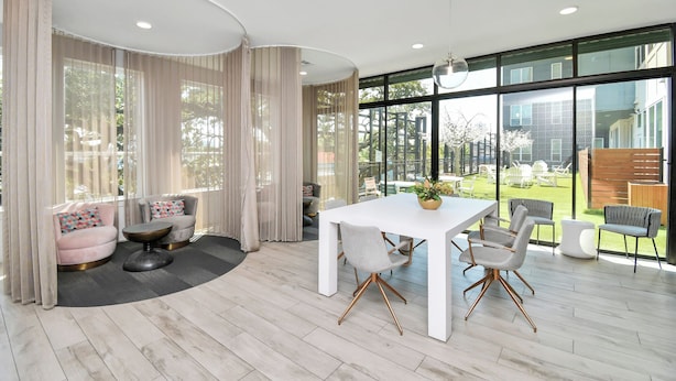 Ein modernes Interieur mit Essbereich, großen Fenstern und Blick ins Freie.