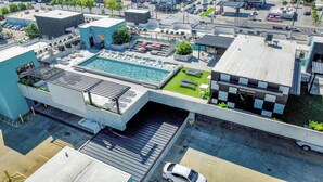 Ein Luftbild eines Hotels mit Dachpool, Außenbereich zum Sitzen und einem Parkplatz.