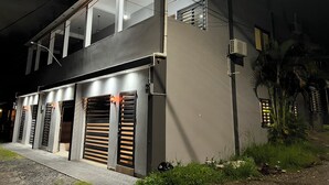 Un edificio moderno con techo plano, ventanas amplias y varios portones de garaje.