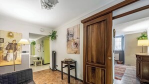 A living room with a sofa, a wooden door, and a hallway leading to another room. - Genova House Via Caffaro, Genova, Italy (Genova)