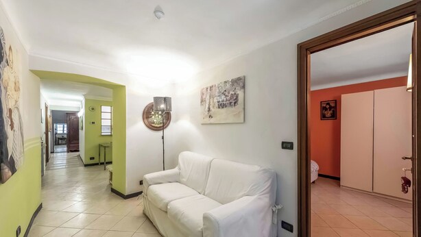 A hallway with a white sofa, a floor lamp, and a painting on the wall. - Genova House Via Caffaro, Genova, Italy (Genova)