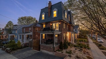 Une maison à deux étages avec une façade en briques, un balcon et une allée.
