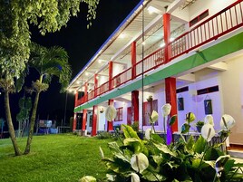 Un hotel de dos pisos con balcones y un césped bien cuidado.