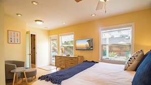 A bedroom with a bed, a dresser, a chair, and a television. - Block to Beach Family Home w/ King Bed, Jacuzzi & BBQ (San Diego)