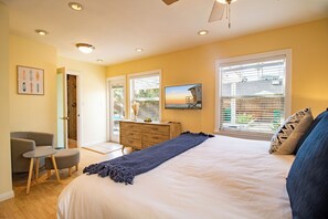 A bedroom with a bed, a dresser, a chair, and a television. - Block to Beach Family Home w/ King Bed, Jacuzzi & BBQ (San Diego)