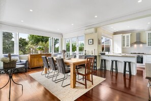 Una cocina amplia con comedor, ventanas grandes y vistas a zonas verdes.
