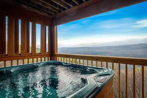 Ein Whirlpool mit einer Holzterrasse und Blick auf die Berge.