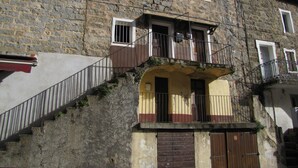 Un edificio in pietra con una scala che conduce a un balcone.