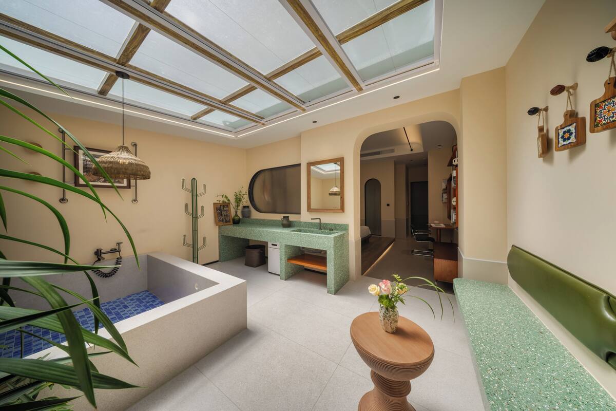 Un baño moderno con tragaluz, bañera, lavamanos y tocador.