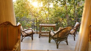 A balcony with wicker furniture, a small table, and a view of greenery. - Wonderful Villa in Lagonisi on the Athenian Riviera (Kalivia Thorikou)
