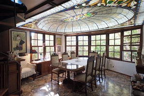 A dining area with a stained glass ceiling, large windows, and a table set for four. - Wonderful Villa in Lagonisi on the Athenian Riviera (Kalivia Thorikou)
