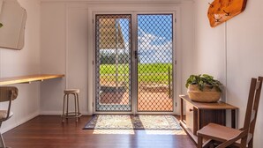 A room with a wooden desk, a chair, a small stool, a potted plant, and a wooden cabinet. - Large family home in a quiet rural location. (Isis Central)
