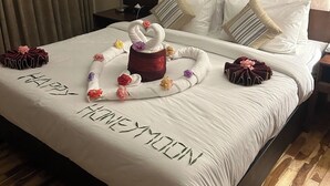 Ein Hotelzimmer mit einem ordentlich bezogenen Bett, Holzboden und Kopfteil.