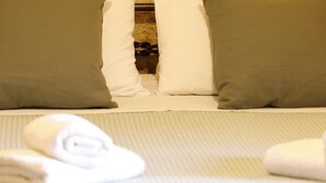 A bed with pillows and rolled towels. - Tholos by Praxithea Stone House & Pool (Chania)