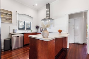 A modern kitchen with a central island, stainless steel appliances, and a large window with a view.