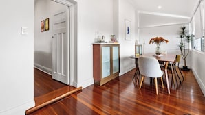 A modern dining area with a wooden table, chairs, and a cabinet. - Heritage Hideaway - North Perth (North Perth)