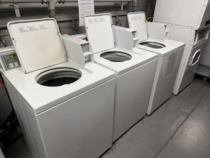 A laundry facility with multiple washing machines and dryers, a control panel, and a sign with laundry etiquette guidelines. - Waikiki Condo with Full Kitchen 5 min Walk to Beach (Honolulu)