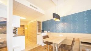 Una cocina moderna con armarios de madera, una mesa de comedor con sillas y una pared azul con un diseño de ondas de agua.