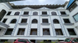 Un edificio de varios pisos con fachada simétrica, numerosas ventanas y techo plano con paneles solares.