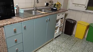 Eine Küche mit Granitarbeitsplatte, Spüle, Herd und Mülleimer.