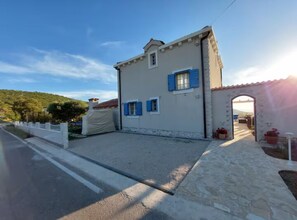 A two-story building with a stone facade, a covered driveway, and an arched entrance. - Villa Mediterranea Seaview Primošten (Primosten)