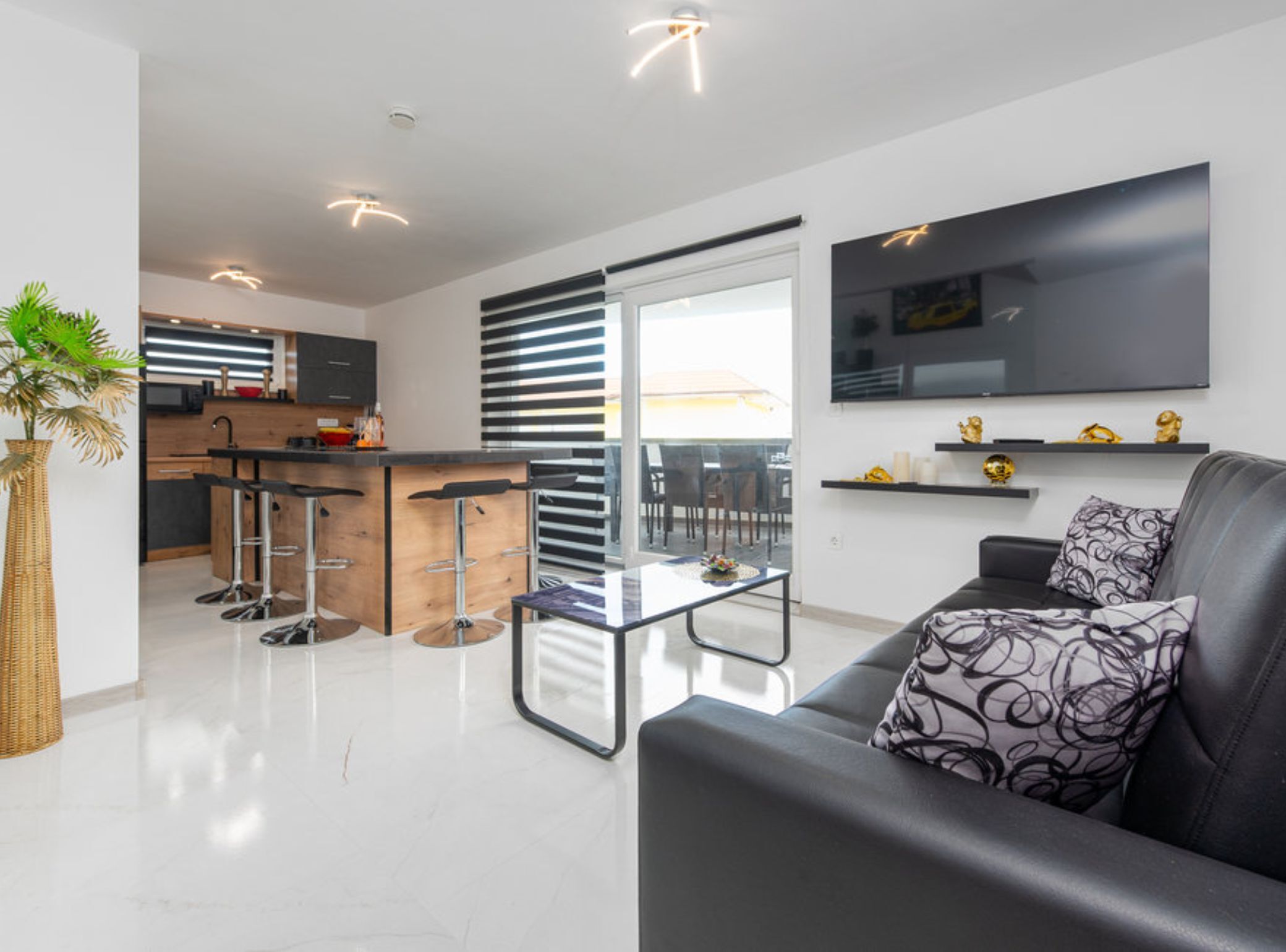 A modern apartment with a kitchen, dining area, and living room.