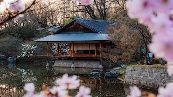 A traditional Japanese-style building with a tiled roof, wooden walls, and a reflection in the water.