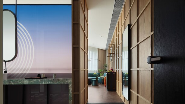A modern interior with a kitchen area, a seating area with a sofa and table, and a view through a large window.