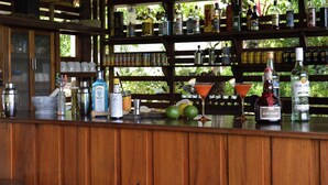 A bar area with shelves of various bottles and a wooden counter.