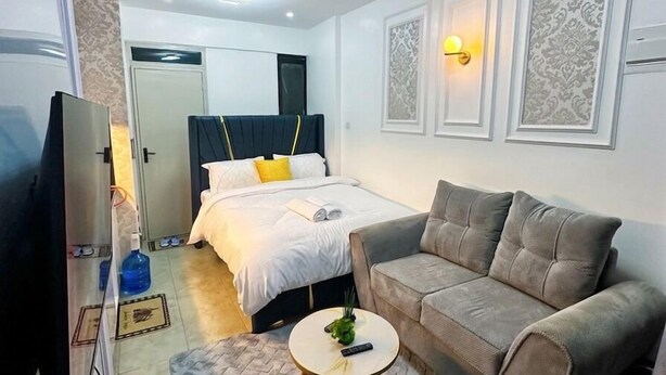 Ein Hotelzimmer mit Bett, Sofa, Fernseher und einem kleinen Tisch.