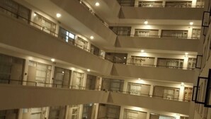 Ein mehrgeschossiges Interieur mit Balkonen, einem zentralen offenen Bereich und einer Treppe.