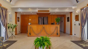 A reception area with a wooden desk, potted plants, and a marble floor. - Stunning Roman Holiday VIlla for 5 (Roma)