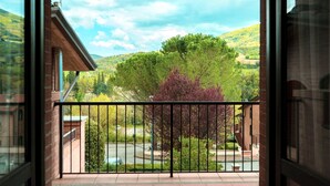 Un balcon donnant sur un paysage verdoyant et des collines.