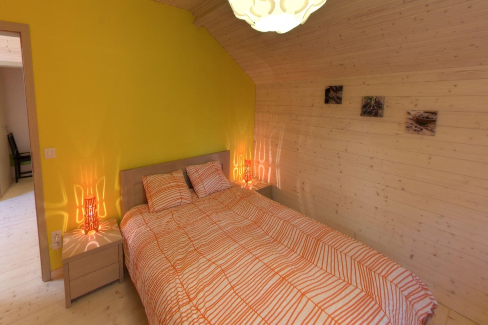 A bedroom with a bed, nightstands, and a wooden ceiling.