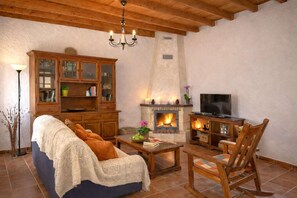 Una sala de estar acogedora con chimenea, muebles de madera y televisor.