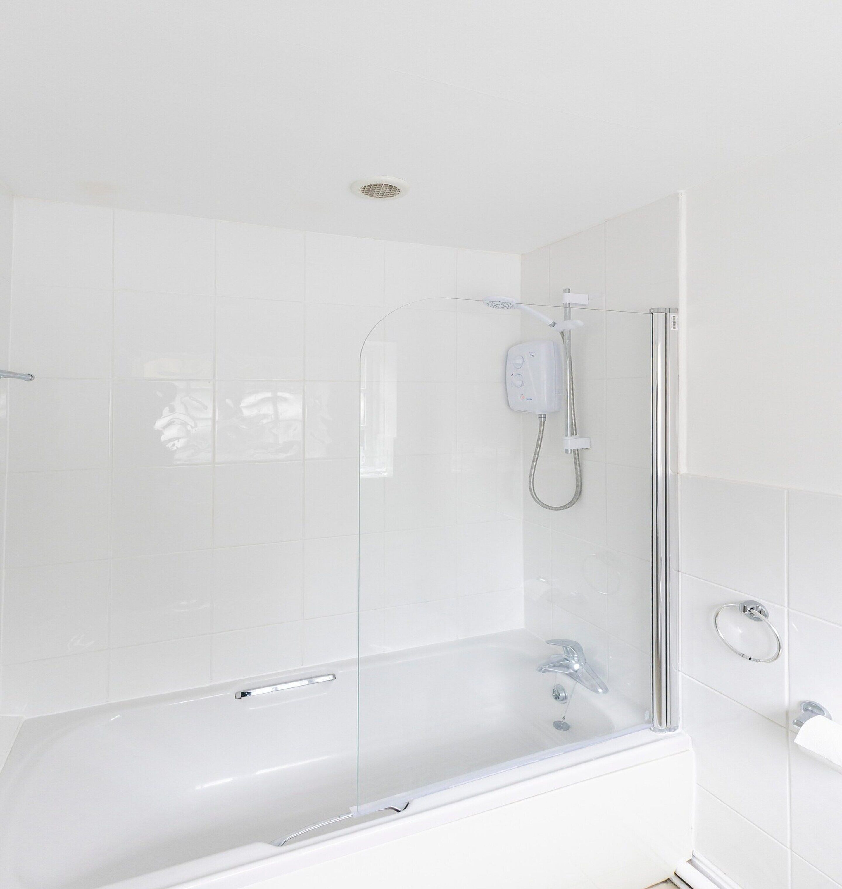 A modern bathroom with a glass-enclosed shower, a standalone bathtub, and a toilet.