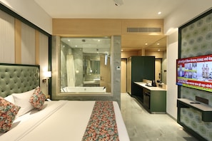 A hotel room with a bed, a bathroom, and a TV screen displaying news. - SiO Suites (Navi Mumbai)