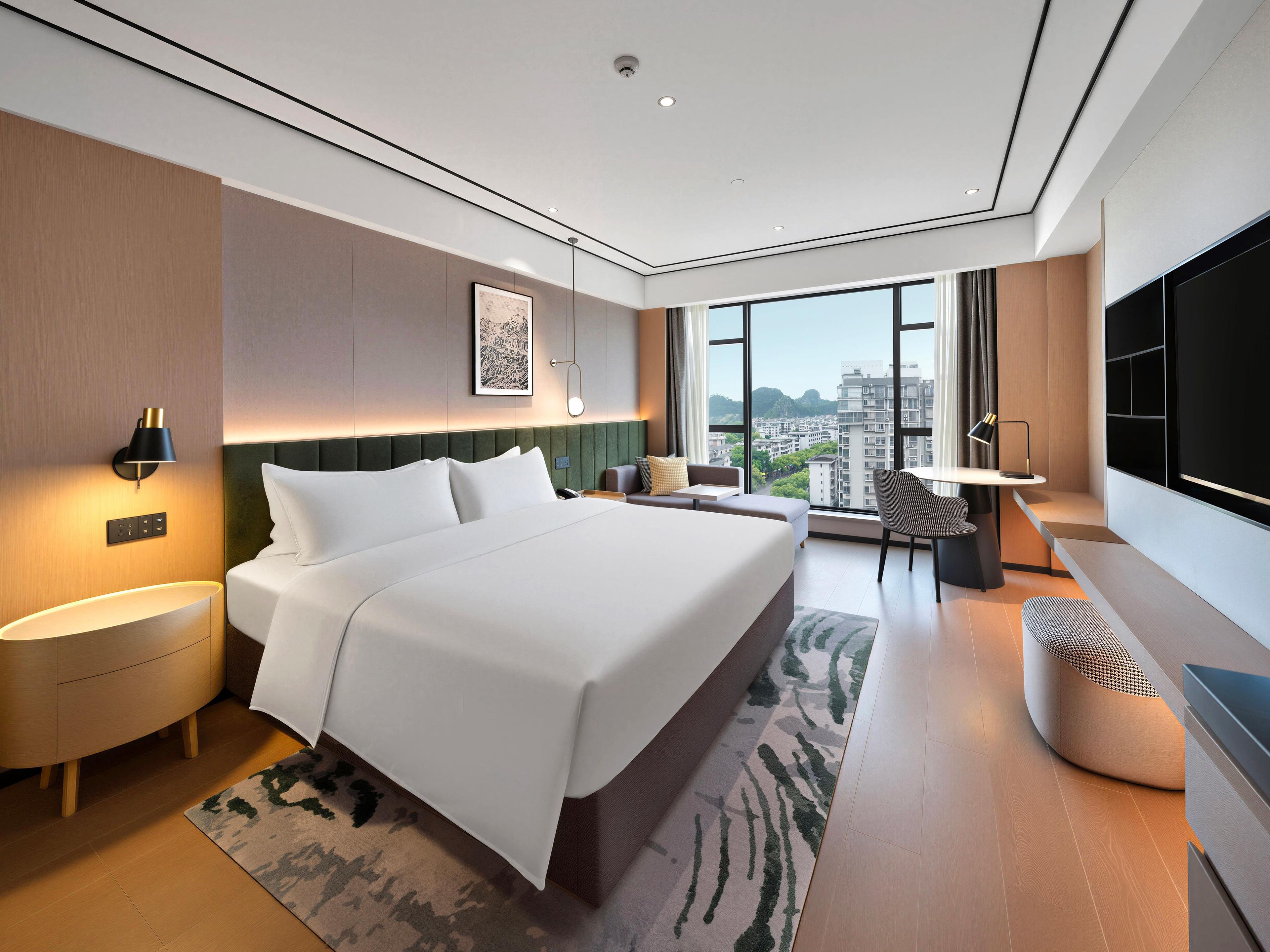 A modern hotel room with a large bed, a desk, a chair, a TV, and a city view.