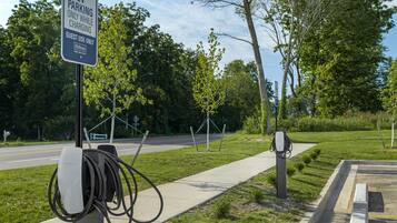 Una estación de carga para vehículos eléctricos con un letrero que indica uso exclusivo para huéspedes de Hilton.