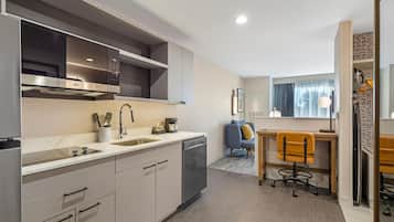 A modern kitchen with a built-in oven, a coffee maker, and a sink.