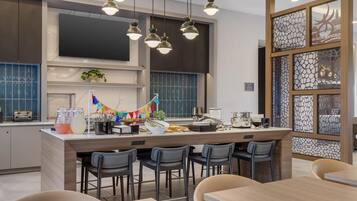 Una cocina moderna con una isla central, taburetes de bar e iluminación colgante.